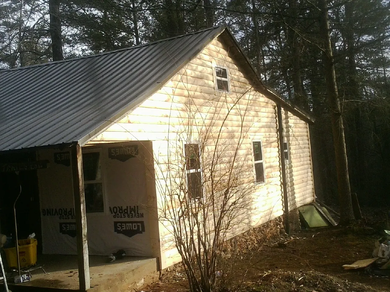 Log siding gable end under a dark metal roof edge in Belfast