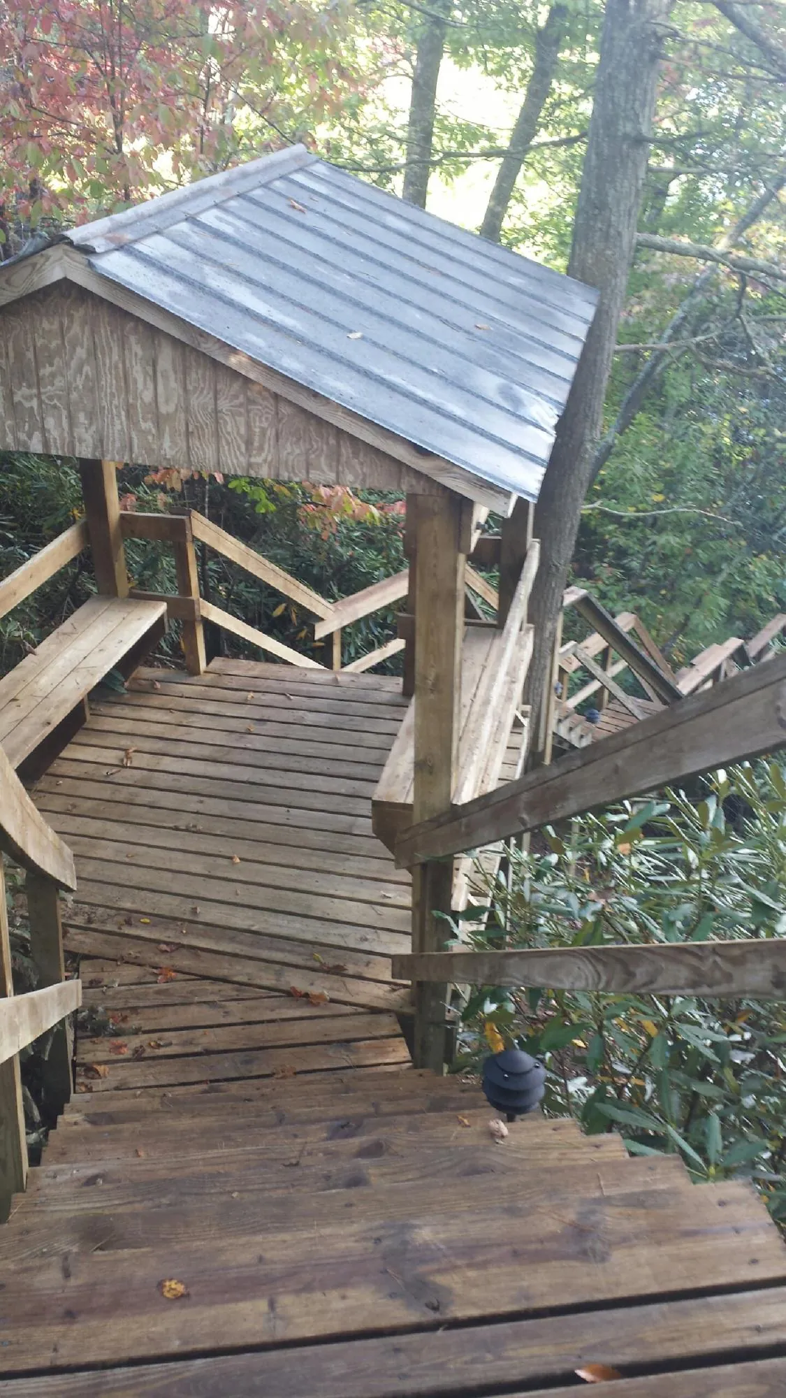 Metal roofed shelter over wooden steps on a wooded walkway — Skylight Repair & Installation work by our crew in Belfast