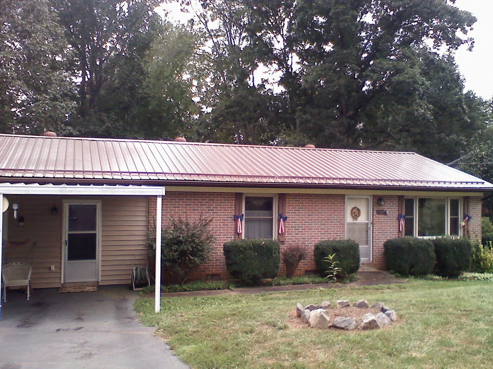 Bronze metal roof and carport on a brick ranch home — Roof Repair work by our crew in Belfast